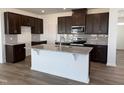 Modern kitchen featuring an island with granite countertops, stainless steel appliances, and elegant wooden cabinetry at 2701 Princess Tree Dr, Raleigh, NC 27616