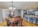 Open-concept dining room features hardwood floors and chandelier lighting, seamlessly connected to the kitchen and living areas at 2940 Bramblegate Dr, Mebane, NC 27302