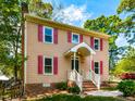 Side view of the house with red car visible in the driveway and mature trees at 3553 E Jameson Rd, Raleigh, NC 27604