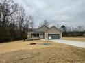 Attractive single-Gathering home with a two-car garage and a cozy front porch, nestled among bare trees at 416 Magnolia Run Way, Benson, NC 27504