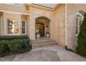 Inviting entryway with stone archway, decorative plants, and a paneled front door at 43 New Rhododendron, Chapel Hill, NC 27517