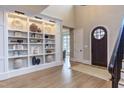 Light-filled foyer with custom shelving and hardwood floors at 5137 Avalaire Oaks Dr, Raleigh, NC 27614