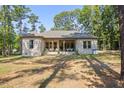 Spacious backyard with a covered patio and lush greenery, perfect for outdoor entertaining and relaxation at 5750 Nc Highway 49, Burlington, NC 27215