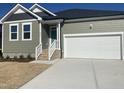 Charming single Gathering home with white garage door, green siding, and well manicured front yard at 813 Emmer St, Rolesville, NC 27571