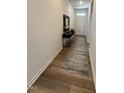 Welcoming entry hall with console table, modern lamp, neutral rug, and wood flooring at 813 Emmer St, Rolesville, NC 27571