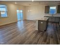 Bright living room with lots of natural light, wood floors, and modern light fixture at 813 Emmer St, Rolesville, NC 27571