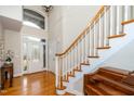 Bright foyer features hardwood floors, staircase with white banister, and a decorative glass front door at 8717 Carradale Ct, Wake Forest, NC 27587