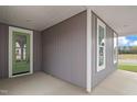 Charming covered gray home entry with a green door, complemented by bright windows and a well-manicured lawn at 9169 Dupree Meadow Dr # 26, Angier, NC 27501