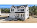 Charming two-story home with gray and white siding, covered porch, and attached two-car garage at 99 Bodacious Ln, Benson, NC 27504