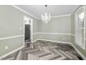 Elegant dining room with herringbone floors and view into the kitchen at 108 Boxford Rd, Morrisville, NC 27560