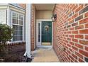 Inviting entryway with a decorative green door, sidelight window and brick exterior at 11213 Presidio Dr, Raleigh, NC 27617