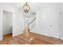 Bright hallway with hardwood floors, classic trim, and a view of the staircase leading to the next level at 11705 Appaloosa E, Raleigh, NC 27613