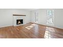 Elegant living room featuring a fireplace, large windows, and pristine hardwood flooring at 11705 Appaloosa E, Raleigh, NC 27613