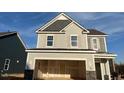 Two-story home showcasing a gray exterior, an attached two-car garage, and a roof under a bright blue sky at 135 Cameron Willow Way Way, Angier, NC 27501