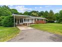 Well-maintained brick home with white trim, green shutters, and a convenient carport at 135 Rainbow Dr, Dunn, NC 28334