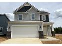 Charming two-story home with a two-car garage, stone accents, and light gray siding at 135 Willow Cameron Way, Angier, NC 27501