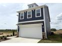 Newly built home with blue vinyl siding, a white two-car garage, and professional landscaping at 136 Willow Cameron Way, Angier, NC 27501