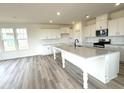 Bright kitchen with quartz counters, a large center island, and stainless steel appliances at 136 Willow Cameron Way, Angier, NC 27501