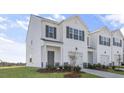 Charming townhome featuring a two-car garage, white siding, and a well-manicured lawn at 220 Starlight St, Sanford, NC 27330