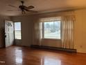 Bright living room featuring hardwood floors, fan, and large window at 405 N Wilson Ave, Dunn, NC 28334