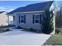 Well-maintained home featuring blue shutters, gray siding, and a freshly poured concrete driveway at 5520 Neuse View Dr, Raleigh, NC 27610