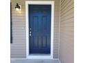 Close-up of a stylish blue front door with white trim and a decorative exterior light fixture at 5520 Neuse View Dr, Raleigh, NC 27610