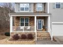 Inviting front porch with stone accents, seating, and a decorative front door creating curb appeal at 617 Hope Valley Rd, Knightdale, NC 27545