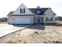 Attractive two-story home featuring a light beige exterior with a dark blue accent gable and a convenient two-car garage at 622 Tart Town Rd, Dunn, NC 28334