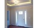 Bright foyer featuring a modern light fixture, crown molding, and a white front door with sidelights at 622 Tart Town Rd, Dunn, NC 28334