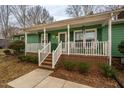 Inviting covered front porch with white railings and brick accents at 623 Rolling Rd, Haw River, NC 27258