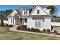 Inviting white home with a manicured lawn and garden beds, enhancing its attractive curb appeal on a sunny day at 654 Christian Light Rd, Fuquay Varina, NC 27526
