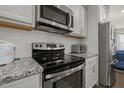 Modern kitchen featuring stainless steel appliances and granite countertops at 781 Fireball Ct, Knightdale, NC 27545