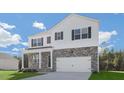 Two-story home featuring stone accents, white siding, black shutters and a well-manicured front lawn at 93 Fair Child Rd, Spring Lake, NC 28390