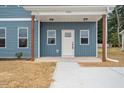 Home's inviting entrance features a covered porch, a white front door, and fresh landscaping at O Shortline Rd, Roxboro, NC 27574