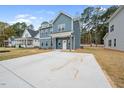The home showcases a concrete driveway leading to the front entrance, surrounded by a well-maintained lawn at O Shortline Rd, Roxboro, NC 27574