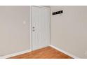 An interior view of a white paneled door with chrome hardware, coat hooks, and wood-look flooring at 108 Ephesus Church Rd # 510, Chapel Hill, NC 27517