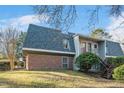 An exterior side view of a two-story home featuring a brick foundation and stairs to the front entrance at 108 Ephesus Church Rd # 510, Chapel Hill, NC 27517