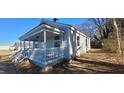 Exterior view of a charming light gray home featuring a covered porch and a well-maintained lawn at 1409 Mcdearman Ave, Rocky Mount, NC 27804