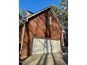 Attached two-car garage with white door and brick siding at 1809 Waddill Way, Henderson, NC 27536