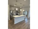 Modern kitchen featuring stainless steel appliances, a center island, and stylish pendant lighting at 19 Oriental St, Angier, NC 27501