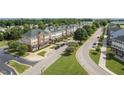 A beautiful neighborhood featuring townhomes, manicured lawns, trees, and pristine streets at 248 Swann Trl, Clayton, NC 27527