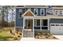 Home featuring a covered front porch with stone accents, wood columns, and stone steps with metal railings at 270 Purslane Dr, Franklinton, NC 27525
