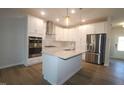 Modern kitchen with stainless steel appliances, white cabinets, quartz counters and a functional kitchen island at 3195 Mission Olive Pl # 352, New Hill, NC 27562