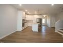 Open-concept living room with hardwood floors flowing into the modern kitchen and stainless appliances at 3195 Mission Olive Pl # 352, New Hill, NC 27562