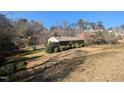 A quaint home nestled on a hillside, surrounded by mature trees and lush greenery at 3501 Turnbridge Dr, Raleigh, NC 27609