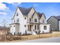 Side view of a striking two-story home featuring white brick and complementary trim at 3812 Cobbler View Way, Fuquay Varina, NC 27526