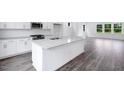 Bright kitchen with white cabinets, stainless appliances, granite countertops and dark laminate flooring at 427 Rowe Way, Knightdale, NC 27545