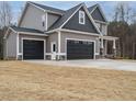 Side view of a beautiful two-story house with a three-car garage and well-maintained lawn at 428 Hampshire Ct, Four Oaks, NC 27524