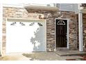 Close-up of a garage and stone facade, next to a black front door with address number 13 at 650 Ganyard Farm Way # 13, Durham, NC 27703