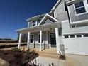 Inviting covered porch with white pillars and stone accents, leading to the front door of this new home at 741 Aristocrat Ln, Knightdale, NC 27545